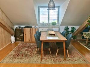 comedor con mesa de madera y sillas en Stadtoase mit traumhaftem Ausblick, en Linz