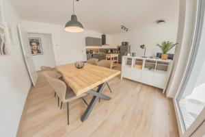 cocina y comedor con mesa de madera y sillas en Luxus Apartment Bad Salzuflen en Bad Salzuflen