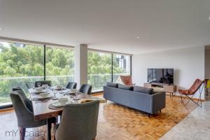 sala de estar con mesa, sillas y sofá en 3 Bedrooms Apartment with Panoramic Terrace, en Ciudad de México