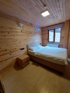 ウズンギョルにあるEŞ Pansiyonの木製の壁のベッドルーム1室