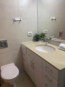 a bathroom with a sink and a toilet and a mirror at Relax Sea View 3BR in Gordon Beach by Holyguest in Tel Aviv