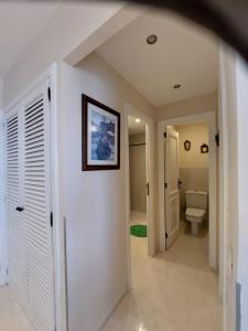 a white bathroom with a toilet and a sink at Apartamento Vistas Paraiso in Adeje