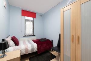 um quarto com uma cama, uma secretária e uma janela em Excel 5min CUSTOM HOUSE STATION parking WIFI sleeps 6 em Londres