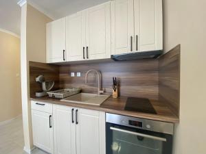 a kitchen with white cabinets and a sink at MARINA BAY 23 Sveti Vlas Beach in Sveti Vlas