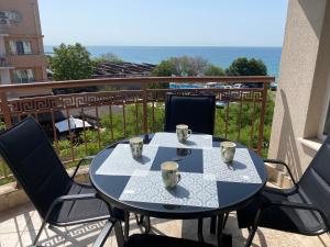 einen Tisch und Stühle auf einem Balkon mit Meerblick in der Unterkunft MARINA BAY 23 Sveti Vlas Beach in Sweti Wlas