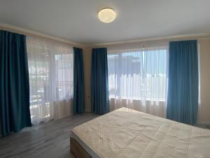 1 dormitorio con cortinas azules, 1 cama y ventana en MARINA BAY 23 Sveti Vlas Beach en Sveti Vlas