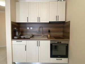 a kitchen with white cabinets and a sink at MARINA BAY 23 Sveti Vlas Beach in Sveti Vlas