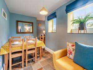 comedor con mesa y silla amarilla en Bo Peep Cottage, en Thornton Dale