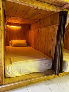 a bedroom with a bed in a wooden cabin at Hostel Tropico 20 PDC in Playa del Carmen