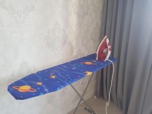 uma mesa azul com um brinquedo em cima em Квартира в центре левого берега Астаны Туран, 46А em Taldykolʼ
