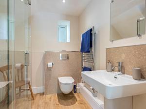 a bathroom with a white sink and a toilet at The Old Stable in Dursley