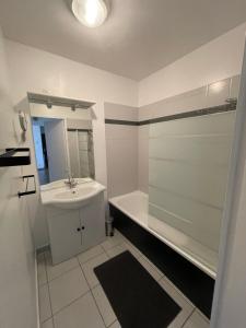 een witte badkamer met een wastafel en een douche bij L'évasion verte in Langres