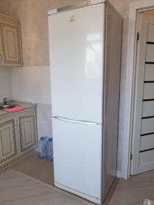 um frigorífico branco numa cozinha ao lado de um balcão em Квартира в центре левого берега Астаны Туран, 46А em Taldykolʼ