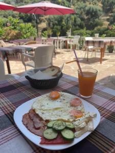 un plato de comida con huevos y verduras en una mesa en Adrian Agustin Rooms, en Lukovë