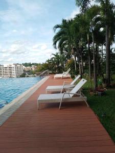 a boardwalk with benches and palm trees next to the water at ONE PAVILLION PLACE in Cebu City