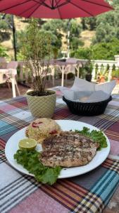 un plato de comida con un pez en una mesa en Adrian Agustin Rooms, en Lukovë