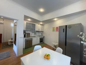 a kitchen with a white table and a refrigerator at Burgães II Apartment in Porto