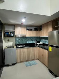 a kitchen with wooden cabinets and a stainless steel refrigerator at ONE PAVILLION PLACE in Cebu City