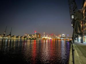a city skyline at night with a body of water at Excel 5min CUSTOM HOUSE STATION parking WIFI sleeps 6 in London