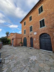 un bâtiment en briques avec deux portes de garage et une étoile au sol dans l'établissement Le volte in Toscana, à Bettolle