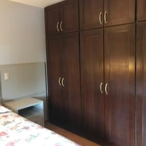 1 dormitorio con armarios de madera y 1 cama en Apartamento Central, Espaçoso Ideal para Família, en Toledo