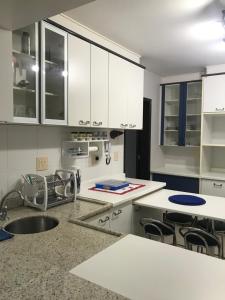 una cocina con armarios blancos y fregadero en Apartamento Central, Espaçoso Ideal para Família, en Toledo