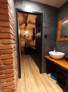 a bathroom with a sink and a brick wall at Biały Domek II in Biszcza