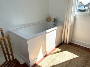 bañera blanca en una habitación con ventana en Bienvenue à la Maison Cayeux Beach en Cayeux-sur-Mer