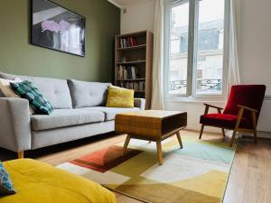 a living room with a couch and a chair at Bienvenue à la Maison Cayeux Beach in Cayeux-sur-Mer
