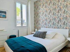 a bedroom with a bed with a blue blanket at Bienvenue à la Maison Cayeux Beach in Cayeux-sur-Mer