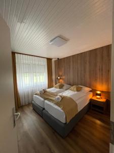 ein Schlafzimmer mit einem großen Bett und einer Holzwand in der Unterkunft Ferienwohnung E in Soltau