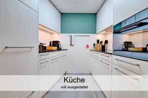 una cucina con armadi bianchi e una parete in vetro di Gemütliche 2.5 Zimmer Wohnung mit privater Sauna a Seewis im Prättigau