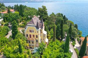a large house on a hill next to the water at Splendid View apartment Opatija in Opatija