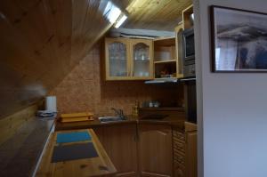 uma cozinha com armários de madeira e um lavatório em Chaloupka v Branne em Branná