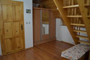 um quarto com uma escada e uma porta de madeira em Chaloupka v Branne em Branná