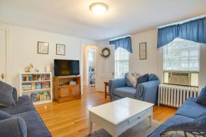 a living room with two blue couches and a tv at 1 Mi to Marina Hyannis Home with Furnished Deck in Hyannis