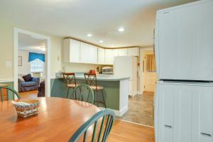 a kitchen and dining room with a table and a refrigerator at 1 Mi to Marina Hyannis Home with Furnished Deck in Hyannis