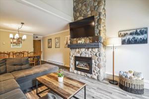 sala de estar con sofá y chimenea en Perfect four bedroom condo with shuttle to the mountain, ski Back Whiffletree D8, en Killington