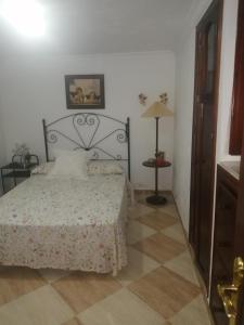 1 dormitorio con 1 cama y suelo de baldosa en EL RINCON DEL MARQUES, en Alcalá de los Gazules