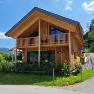 a large wooden house with a large balcony at Alpenchalét Alpakablick in Sankt Lorenzen ob Murau