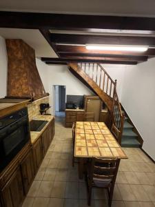 een keuken met een houten tafel en een trap bij Gîte le clos in Saint-Sulpice-de-Faleyrens