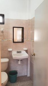 La salle de bains est pourvue d'un lavabo, de toilettes et d'un miroir. dans l'établissement Hotel Jacaranda, à Tuxtla Gutiérrez