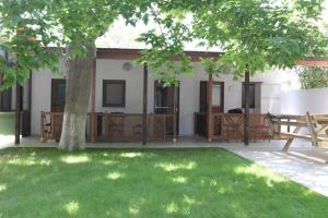 a house with a green yard with a tree at Chiyanno's Inn in Dalyanköy