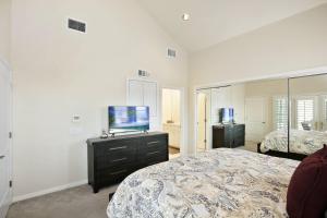 a bedroom with a bed and a flat screen tv at 416 Dahlia in Newport Beach