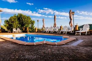 einen Pool mit Stühlen und Sonnenschirmen auf einer Terrasse in der Unterkunft La Atalaya in Frailes