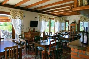 a dining room with wooden tables and chairs and windows at Country House Salomè in Musile di Piave