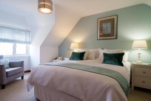 a bedroom with a large bed and a chair at Twiga House Bed and Breakfast in Wareham