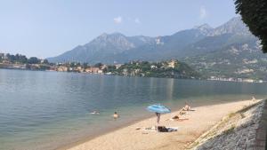 a group of people on a beach with an umbrella at Casa vacanze in centro in Lecco