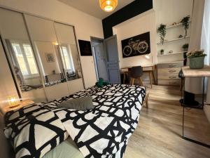 - une chambre avec un lit noir et blanc et un bureau dans l'établissement Splendide Appartement Joliette parking securisé, à Marseille