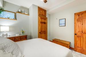 um quarto com uma cama branca e uma porta de madeira em Lakefront Orange Vacation Rental - Pet Friendly! em Orange